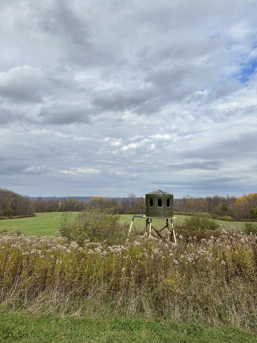 Elevated box blind on the edge of a field in fall